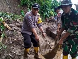 Sinergitas, Polisi Bersama TNI dan Warga Bersihkan Material Bencana Tanah Longsor di Mojokerto