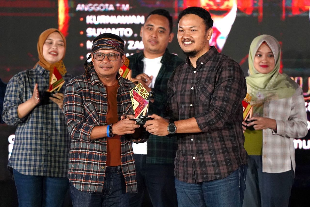 Direktur Utama SIG Donny Arsal (kedua kiri), menyerahkan trofi pada M. Ardy Zailani (kedua kanan), tim Miner Empire 2.2, pemenang Best of The Best SIG Innovation Awards, di Sasono Langen Budoyo TMII, Jakarta, pada Sabtu (7/1).
