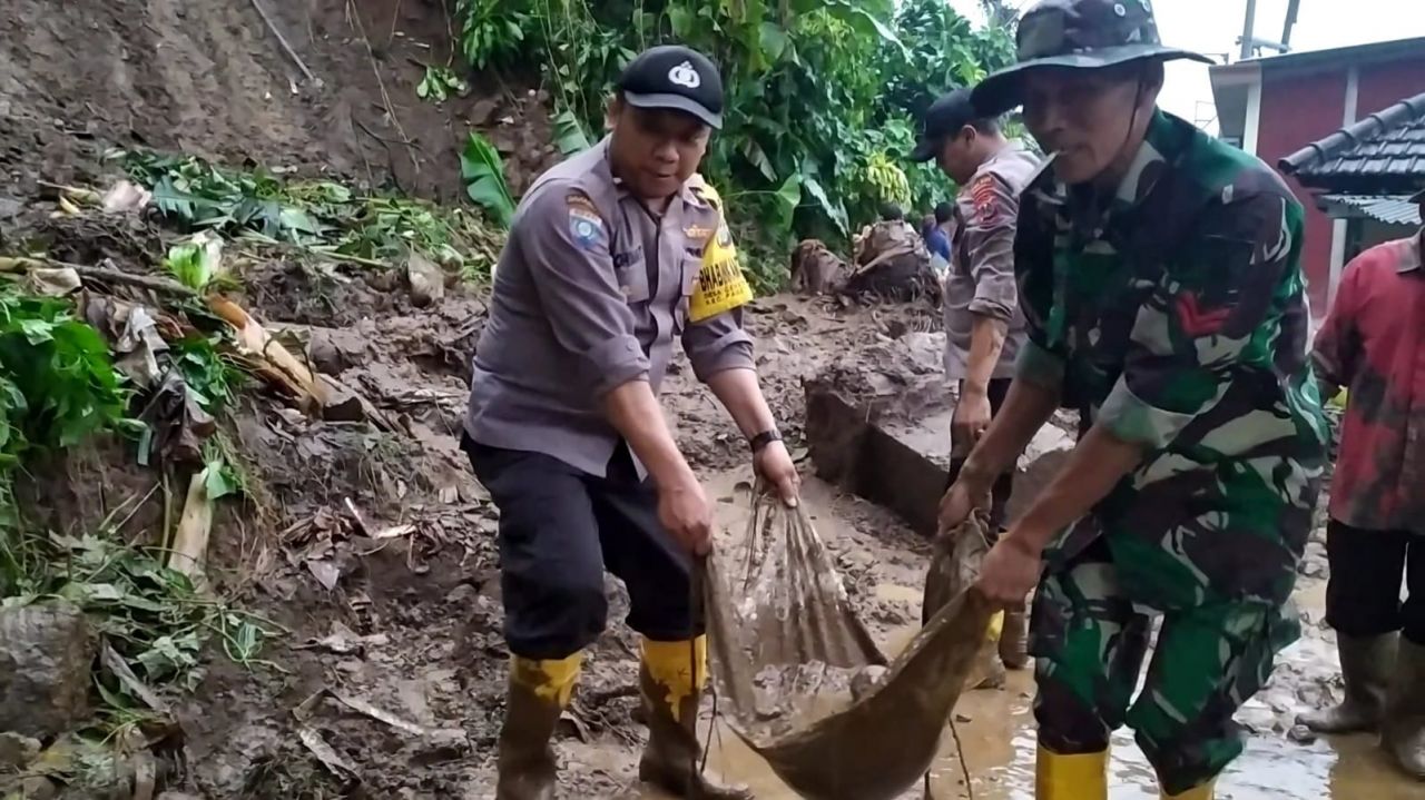 Sinergitas, Polisi Bersama TNI dan Warga Bersihkan Material Bencana Tanah Longsor di Mojokerto