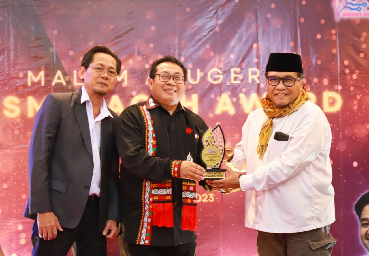 Pj Bupati Pidie Ir Wahyudi Adisiswanto saat menerima penghargaan dari SMSI Aceh