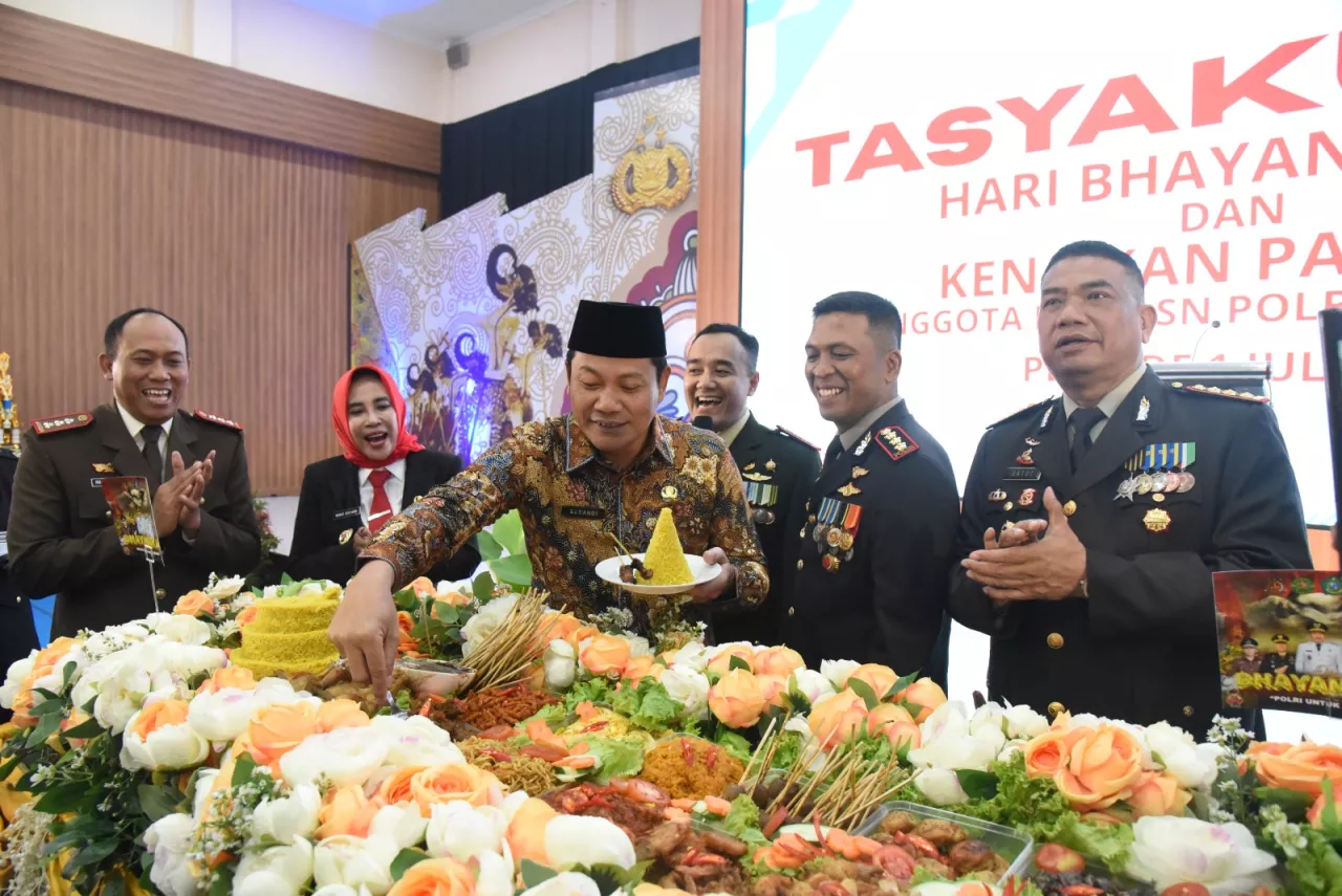 Suasana potong tumpeng oleh Bupati Sidoarjo Subandi seusai upacara Hari Bhayangkara di Sidoarjo.