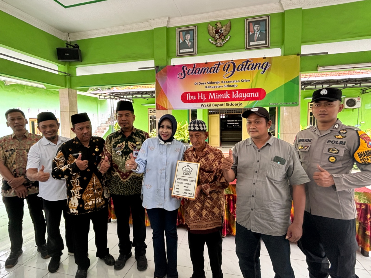 Wakil Bupati Sidoarjo, Mimik Idayana, secara simbolis menyerahkan bantuan rehabilitasi Rumah Tidak Layak Huni (RTLH) dari Dinas Perumahan, Permukiman, Cipta Karya dan Tata Ruang (DP2CKTR) kepada warga Desa Sidorejo, Kecamatan Krian, Kamis (15/1/2026).