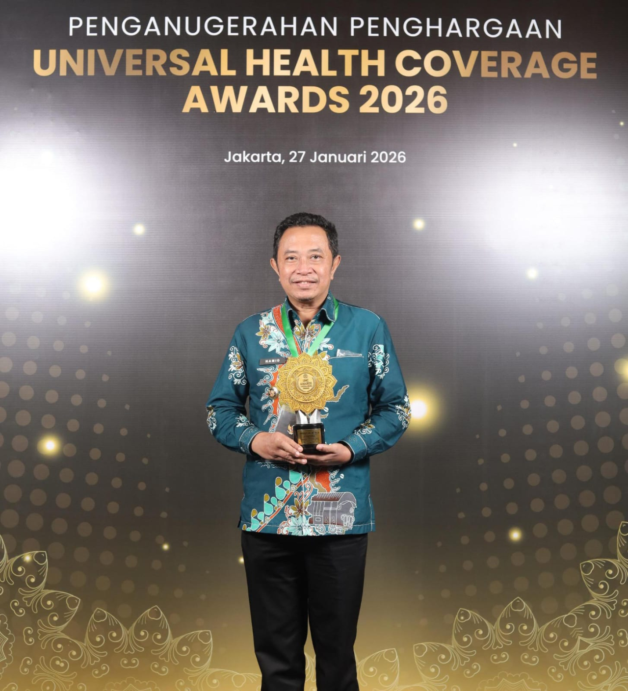 Bupati Bondowoso Abdul Hamid Wahid menunjukkan Universal Health Coverage (UHC) Award 2026 Kategori Pratama untuk Pemkab Bondowoso dari BPJS Kesehatan di ajang UHC Awards di JIExpo, Kemayoran , Jakarta, Selasa (27/1/2026).