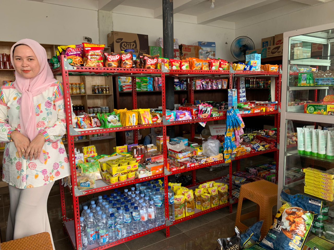 Seorang karyawati gerai Minimarket milik BUMdes As-Salam Desa Asembagus Kecamatan Asembagus Kab. Situbondo tengah berada di sejumlah produk komoditas yang dijual. (Foto TPP Situbondo for JatimUPdate.id)