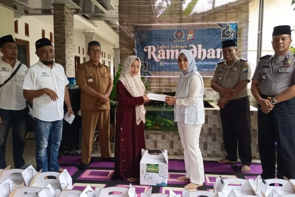 Ketua PWI Bondowoso Sinca Ari Pangestu menyerahkan santunan kepada warga dalam kegiatan Safari Sedekah Ramadhan yang digelar PWI Bondowoso bersama Polres Bondowoso di Desa Banyuwulu, Kec. Wringin.
