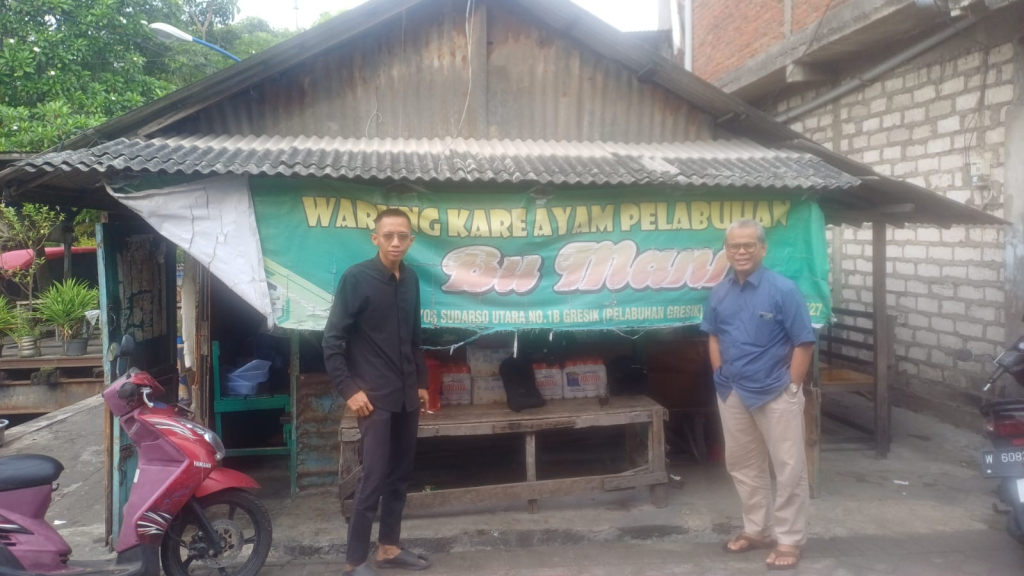 Tokoh Masyarakat Gresik, Achmad Rubai bersama jurnalis JatimUPdate.id di depan warung Kare Ayam Pelabuhan Bu Mani, Jumat (27/03/2026). (Foto JatimUPdate.id)
