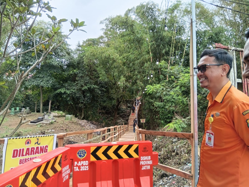 Kepala Pelaksana BPBD Bondowoso, Kristianto Putro Prasojo, meninjau jembatan darurat penghubung Nangkaan–Sukowiryo yang ditutup sementara akibat kerusakan diterjang arus sungai, Senin (27/4/2026).