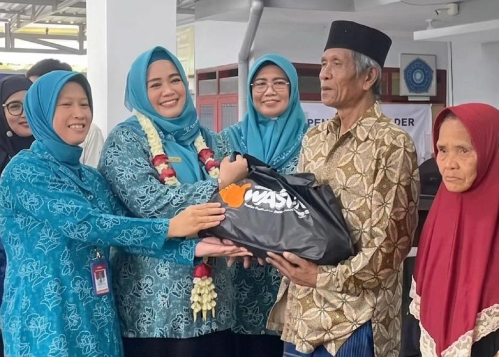 Ketua TP PKK Bondowoso Khodijatul Qodriyah menyerahkan bantuan kepada warga dalam kegiatan penguatan Integrasi Layanan Primer (ILP) Posyandu di Kecamatan Tapen, Senin (27/4/2026).