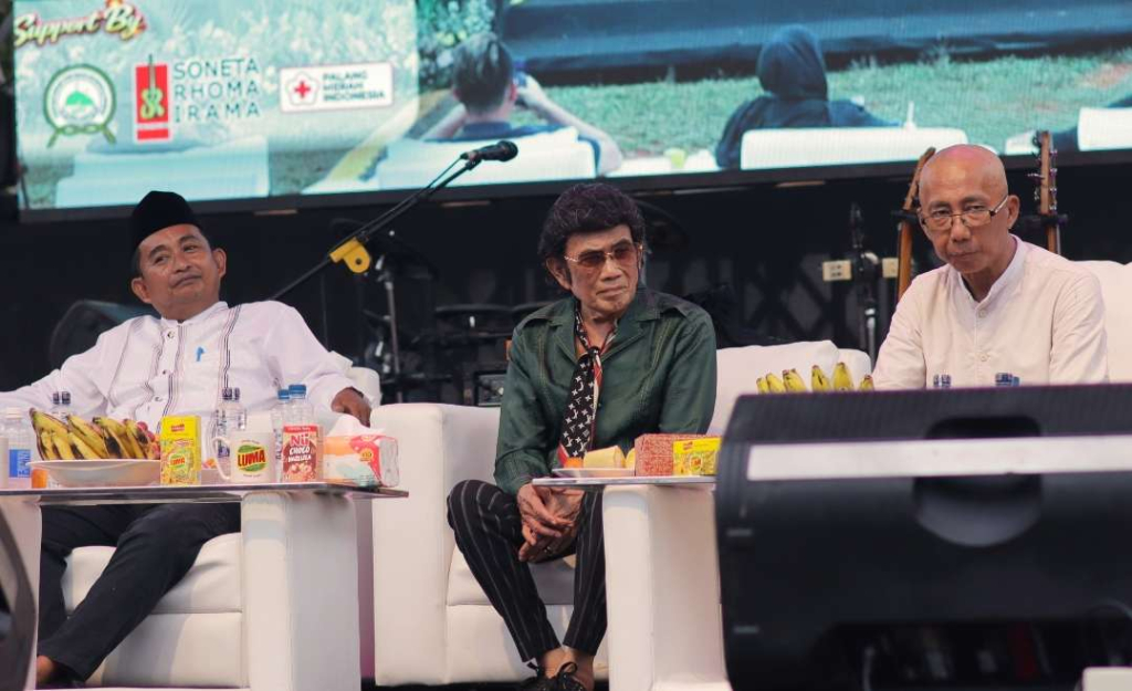 Rhoma Irama tengah, Ramdansyah di sisi kanan dan logo PMI di latar belakang
