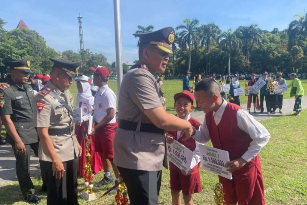Kapolres Bondowoso AKBP Aryo Dwi Wibowo memberikan ucapan selamat kepada siswa penerima penghargaan pada peringatan Hardiknas 2026 di Alun-Alun RBA Ki Ronggo, Senin (4/5/2026).