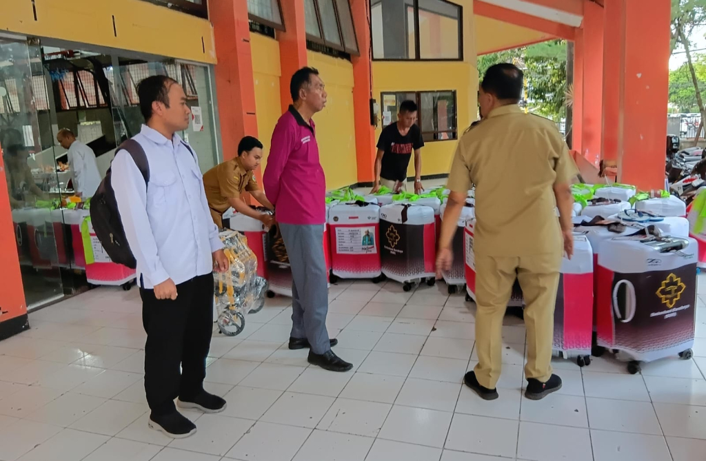 Petugas melakukan pengecekan koper milik jemaah calon haji Bondowoso menjelang keberangkatan menuju Embarkasi Surabaya, Senin (11/5/2026).