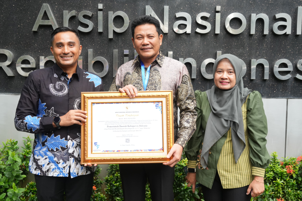Bupati Sidoarjo Subandi bersama Kepala Disperpusip Kabupaten Sidoarjo Rudi Setiawan di Gedung Arsip Nasional dengan plakat penghargaan.