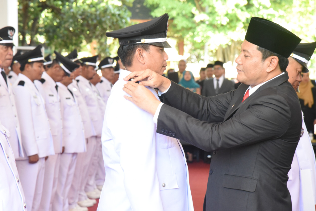 Bupati Sidoarjo Subandi menyematkan tanda kepangkatan pada seorang Kades yang dilantik bersama rekan 80 orang lainnya.