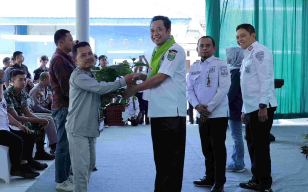 Bupati Bondowoso Abdul Hamid Wahid menyerahkan bibit kopi kepada perwakilan petani setelah penandatanganan Perjanjian Kerja Sama (PKS) pengelolaan wisata dan agroforestri bersama Perhutani di Kecamatan Sumber Wringin, Rabu (8/7/2026).