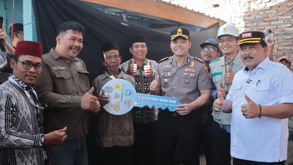 Kapolres Nganjuk AKBP Suria Miftah Irawan menyerahkan replika kunci rumah kepada Mbah Sojo didampingi Bupati Nganjuk Marhaen Junaidi serta Ketua PWI Nganjuk Bagus.