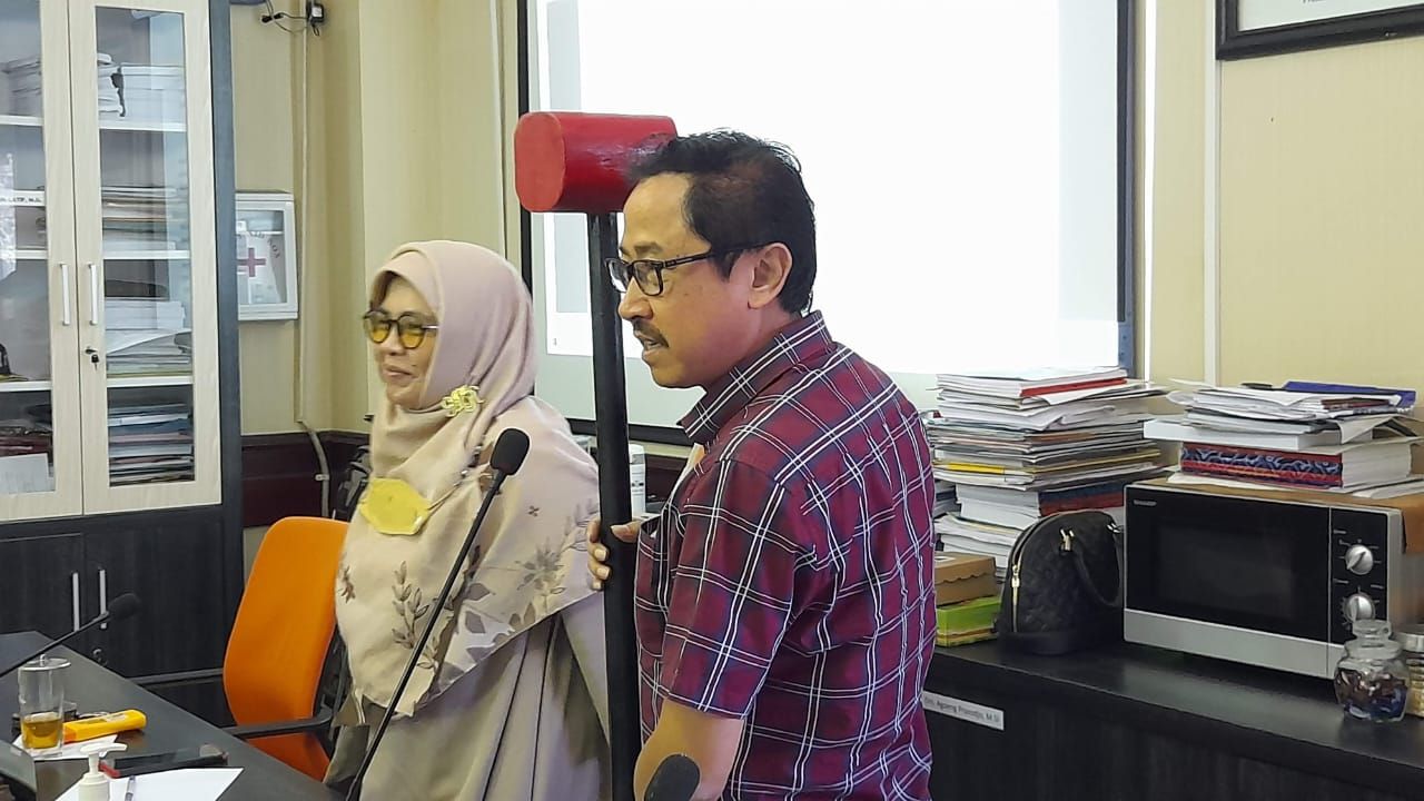 Baktiono saat menunjukkan simbol palu besar untuk diberikan kepada Cak Ji sebagai bentuk keberanian menegakkan perda